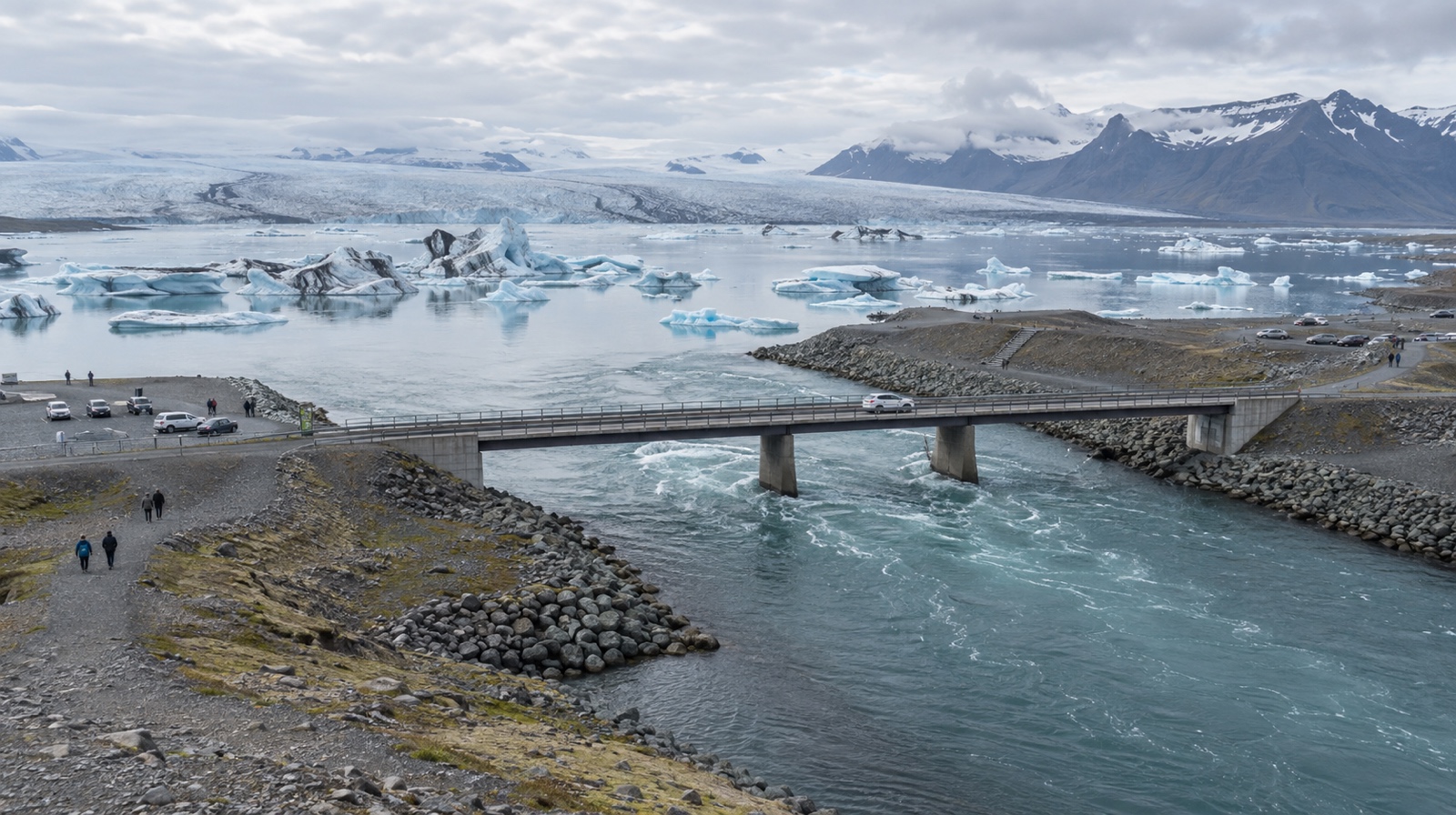 Elevated view showing the Route 1 bridge, lagoon-side path, and both car parks at Jökulsárlón