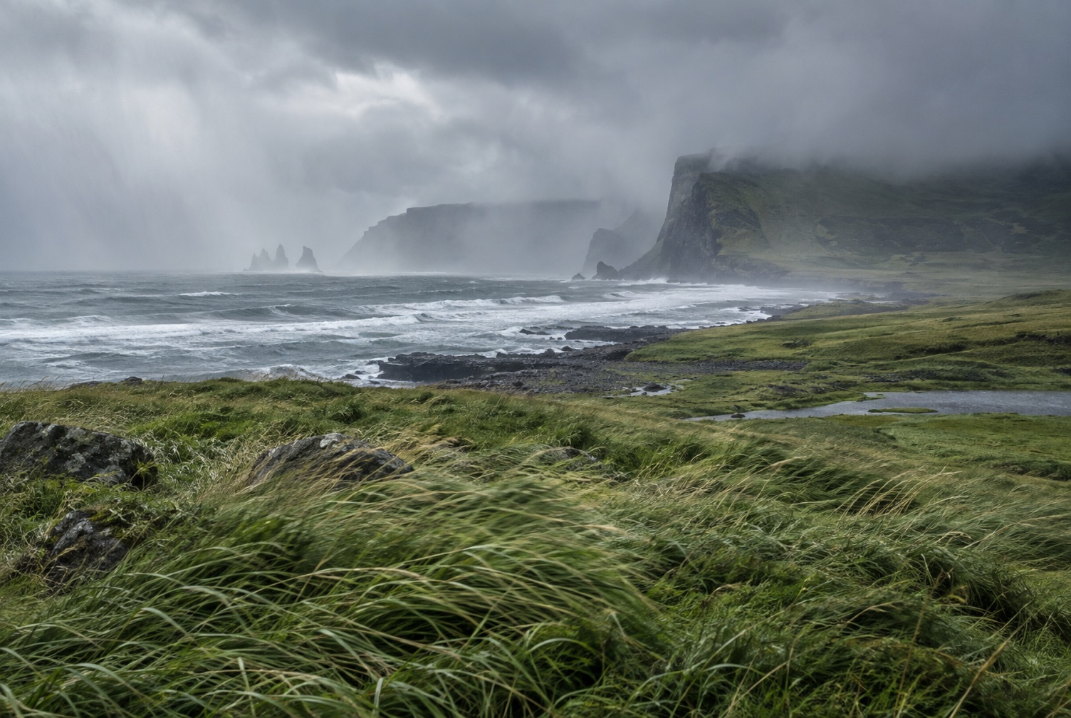 Wind-blown rain or low cloud crossing the open South Coast with a safe roadside scale cue